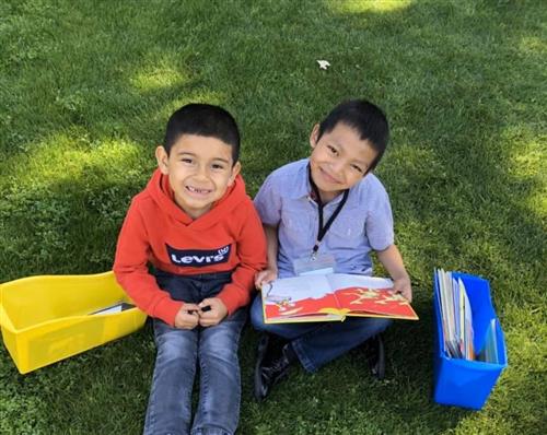students read together on the grass